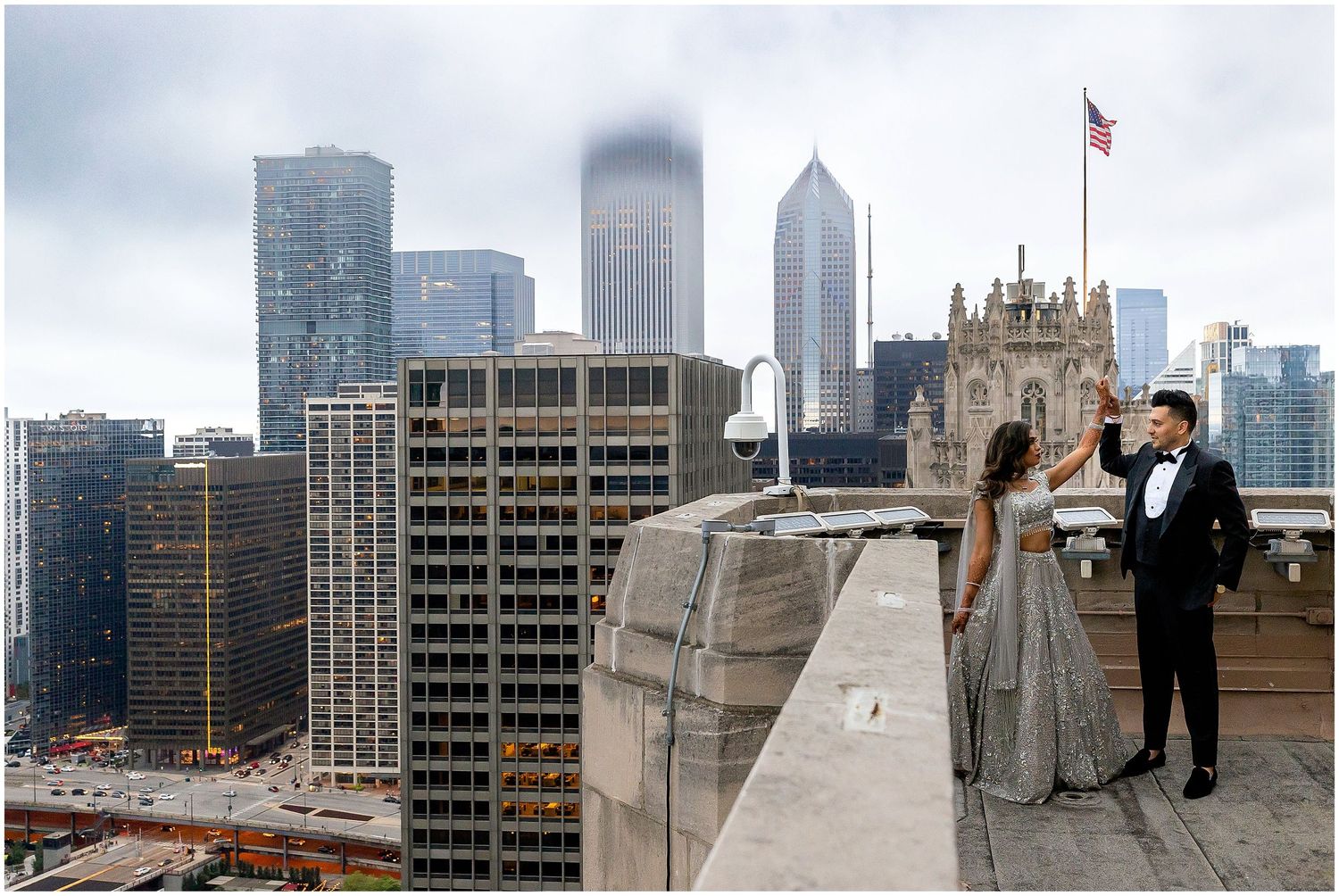 Stunning urban rooftop photoshoot with dramatic Chicago skyline and gothic architecture in background.