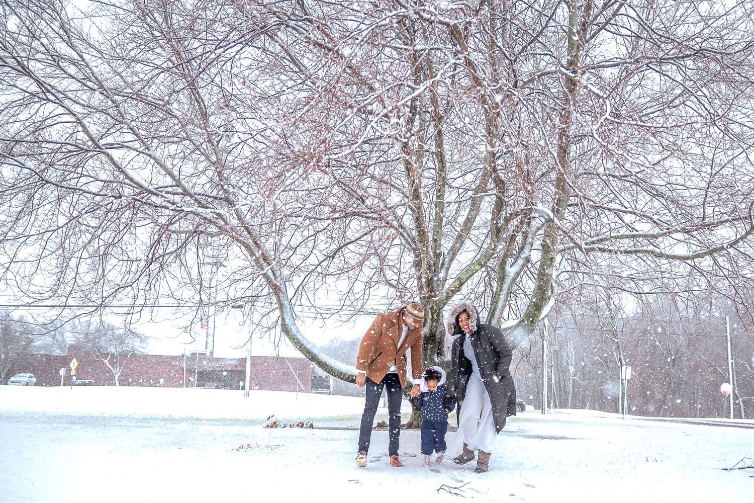 mother father and daughter walking in the snow