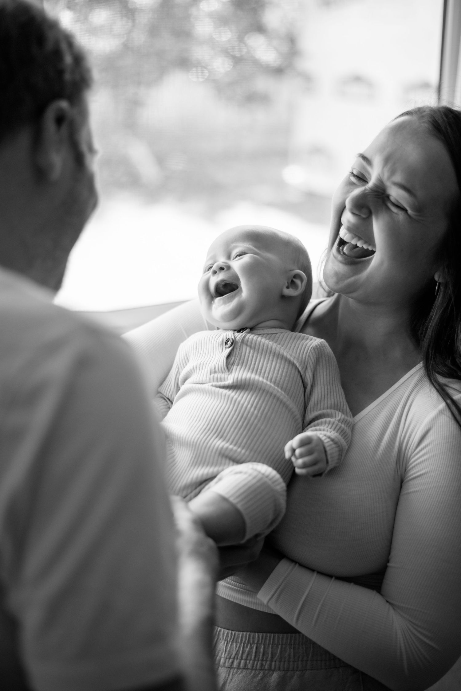 A heartwarming moment of shared laughter captured in black and white photography.