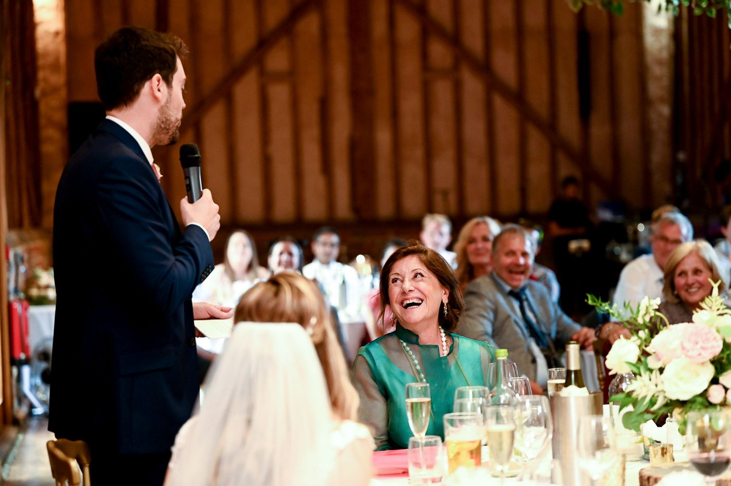 Wedding reception speech brings laughter and joy to guests during celebration.