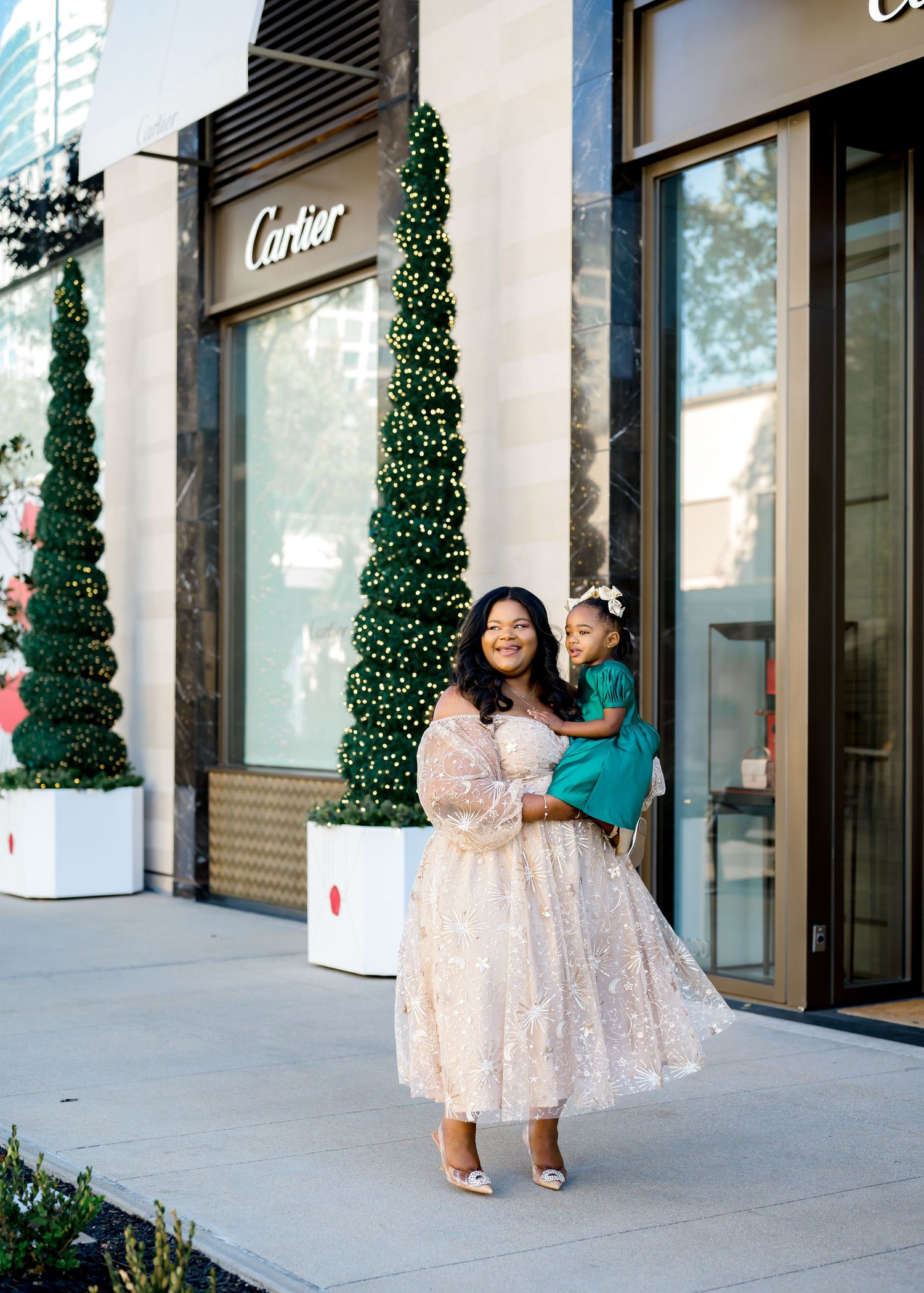 Festive holiday portraits outside Cartier store with decorated topiary trees.