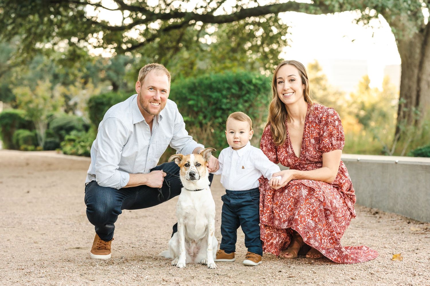 Family outdoor portrait session with dog at sunset in natural setting.