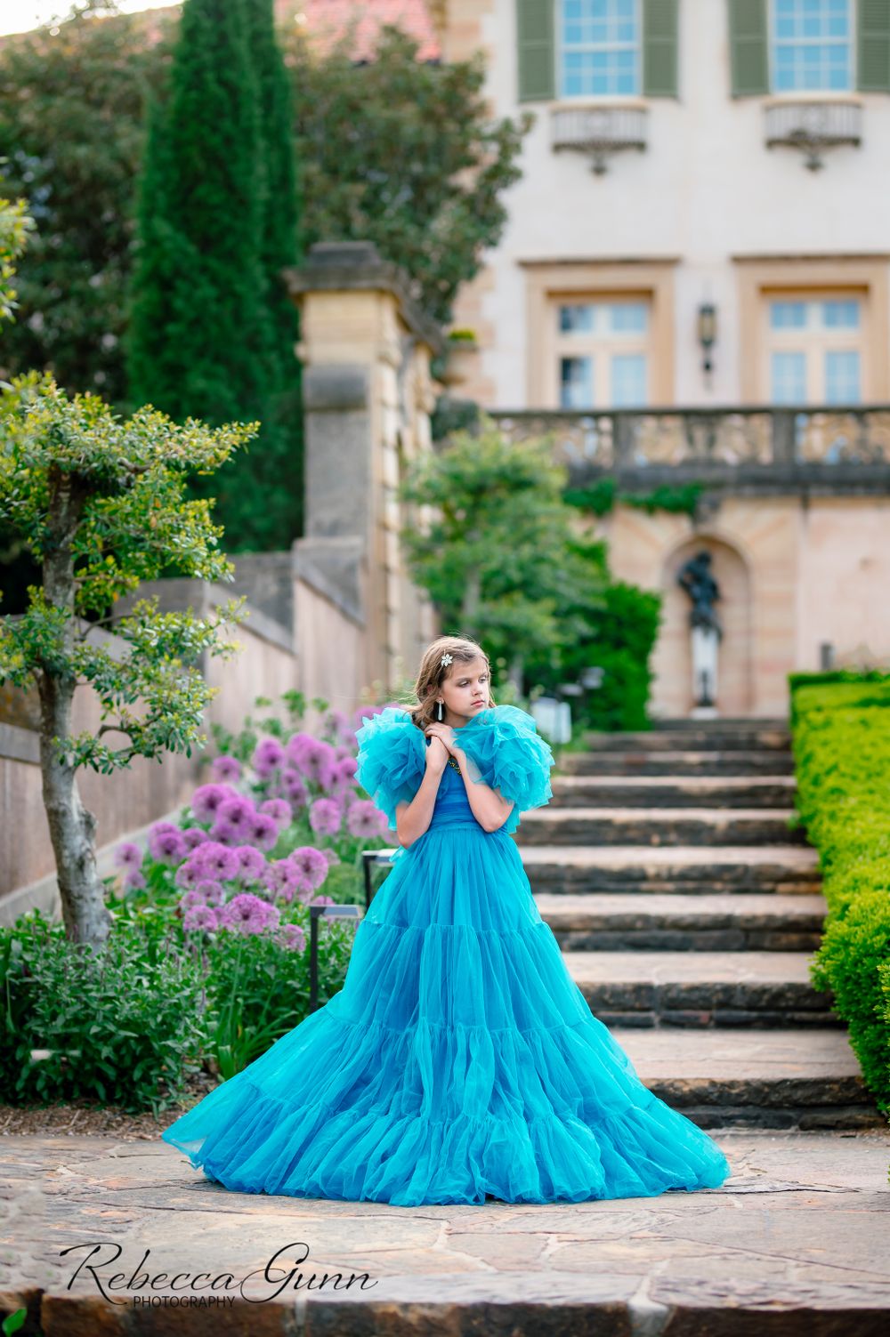 Turquoise blue ruffle child couture gown on steps of Philbrook Museum in Tulsa during spring by featured photographer