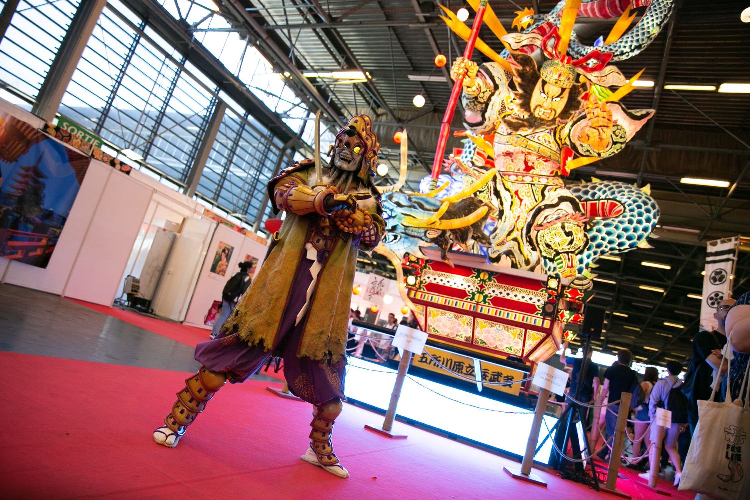 Colorful traditional Japanese festival float with ornate decorations displayed at an indoor cultural event.