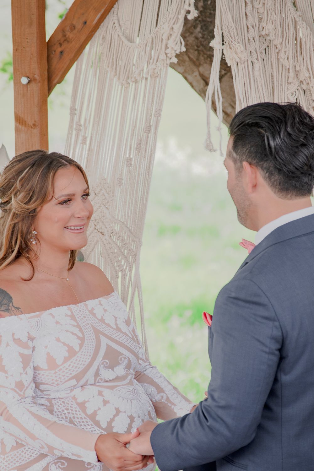 Man & Woman become husband and wife. Holding Hands, Man is looking into wife's eyes. Wife Smiling. Macramé  BOHO