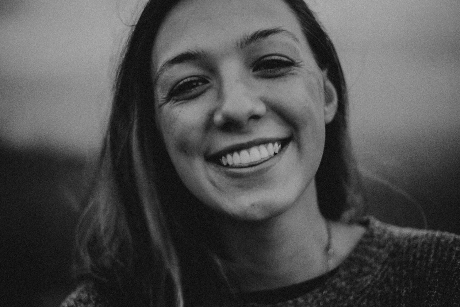 Black and white portrait of person with bright genuine smile.