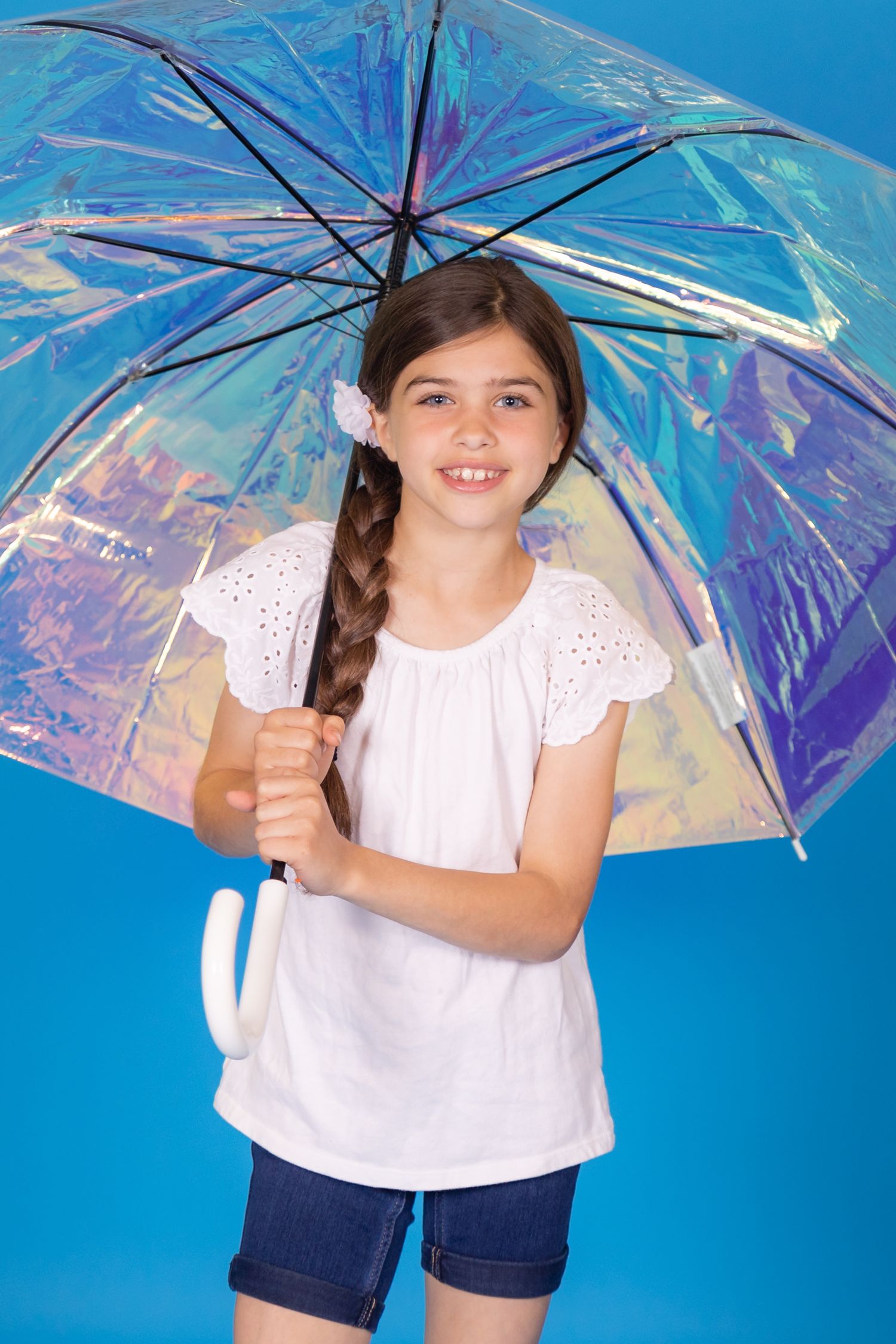 girl holding iridescent umbrella on savage blue jay backdrop in studio in clayton new jersey Gloucester county