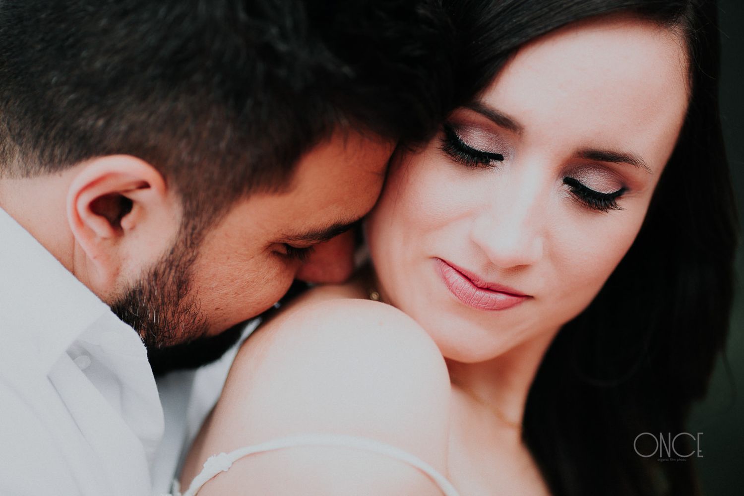 Intimate black and white portrait of a couple sharing a tender moment.