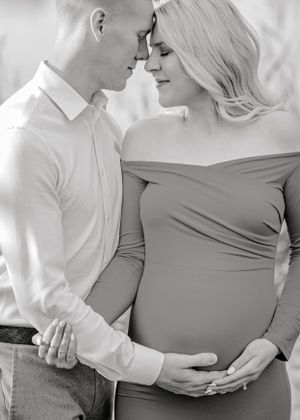 Intimate black and white maternity photo of couple in soft, minimalist style.