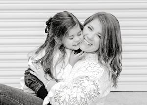 Black and white portrait showing tender moment between parent and child.