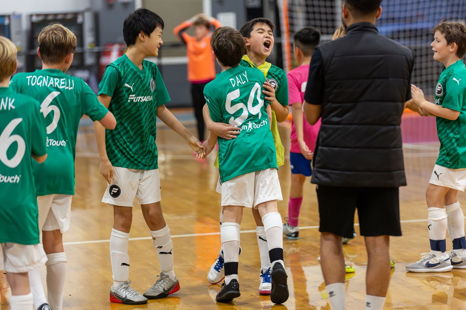 Players in green jerseys stand in formation during a team sporting event.