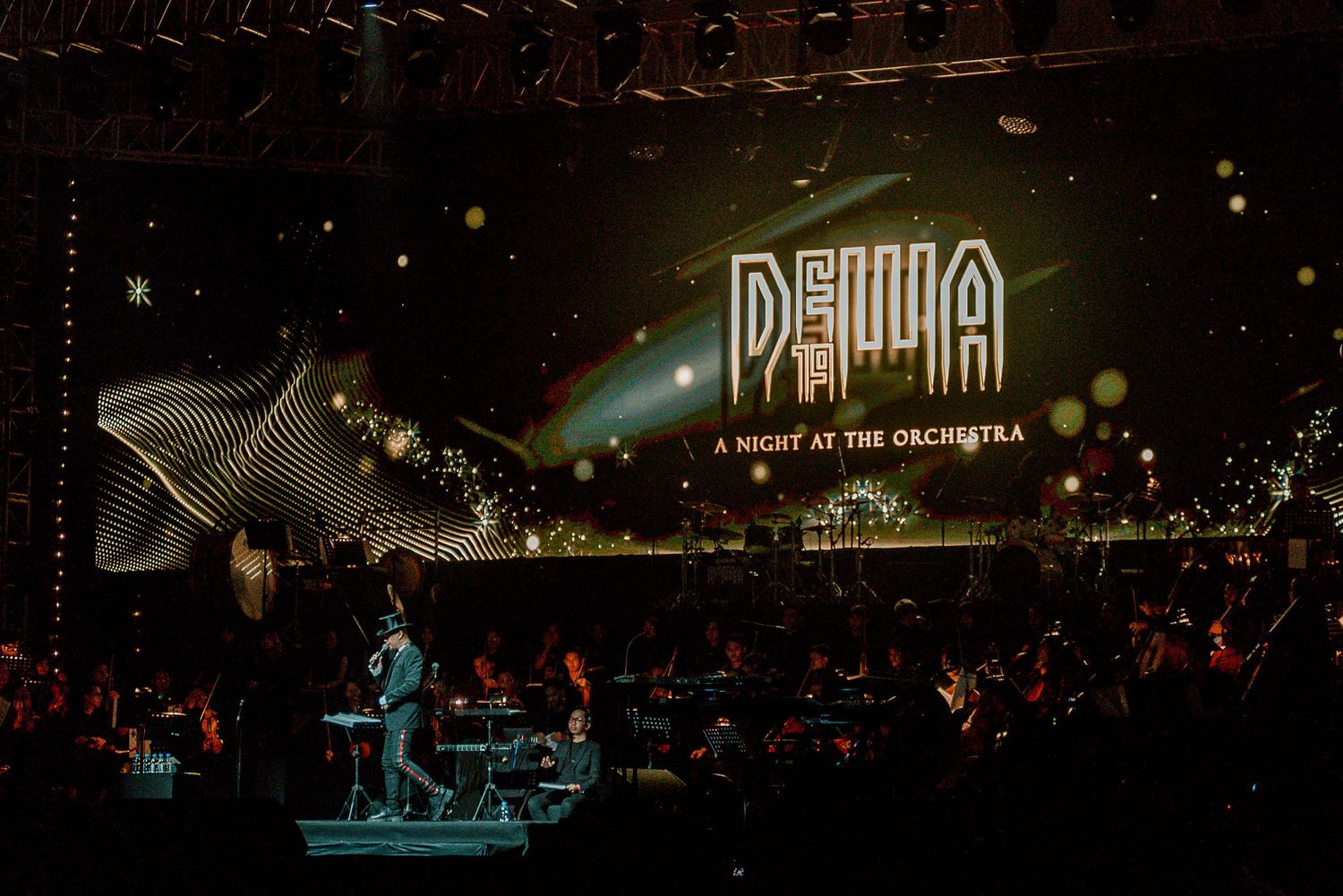 Concert stage with illuminated DEHUA sign and orchestral performers under dramatic lighting.