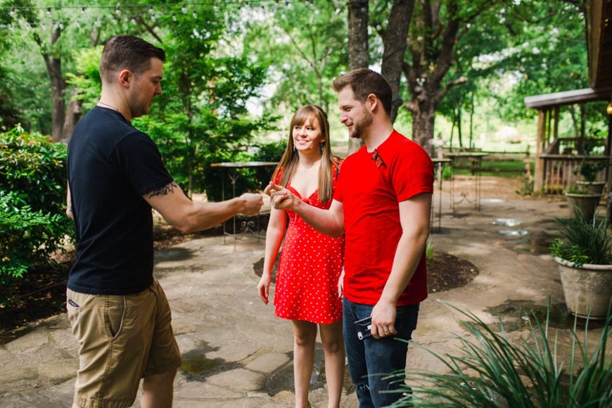 People interacting in a lush garden setting with stone pathways.