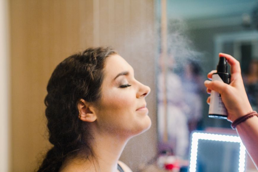 Beauty preparation scene with hair styling products being applied.