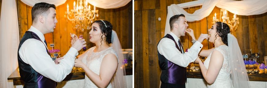 A couple shares cake during their wedding reception in an elegantly lit venue.