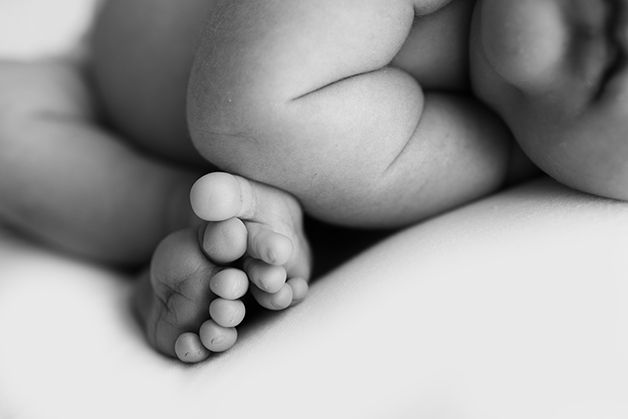 Black and white image of newborn baby girl's tiny toes.