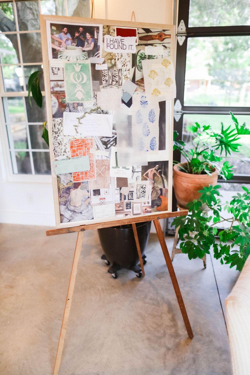 Creative workspace with inspiration board, wooden desk, and potted plants.