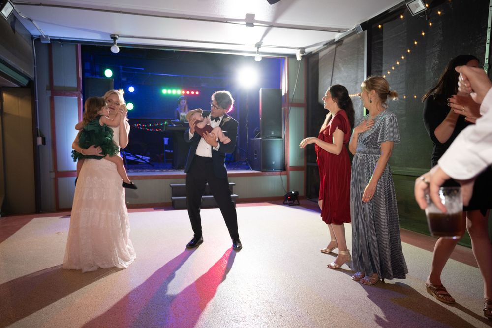 Wedding reception dance scene with guests enjoying celebrations under indoor lighting.