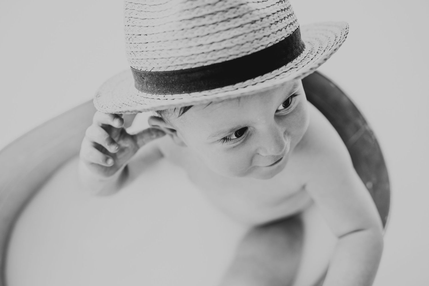 Classic straw fedora hat creates vintage summer style in black and white.