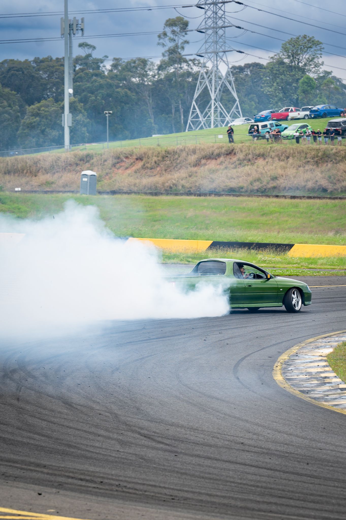 green ute doing a skid on a race track