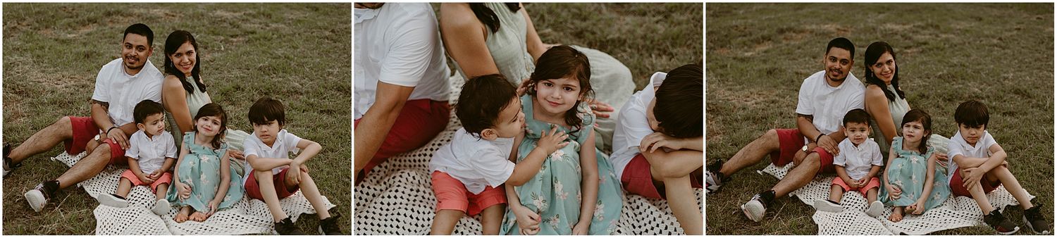 Family sitting together on a blanket enjoying quality time outdoors.