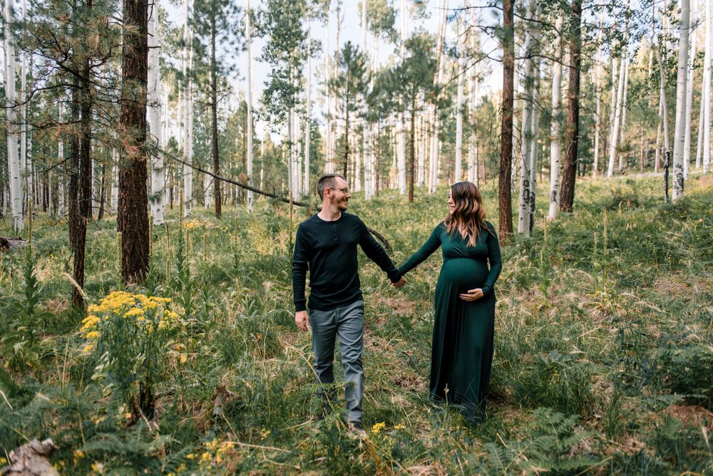 People walk together through a scenic forest filled with tall birch trees.
