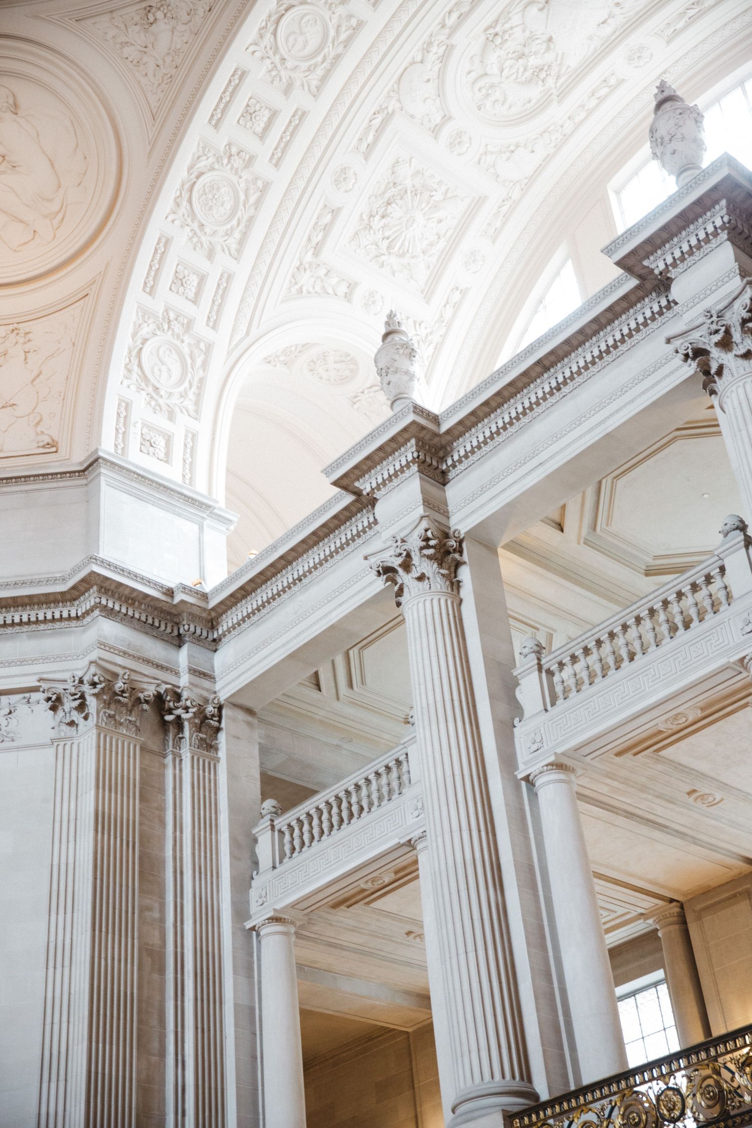 Elegant white classical interior featuring ornate columns and decorative ceiling moldings.