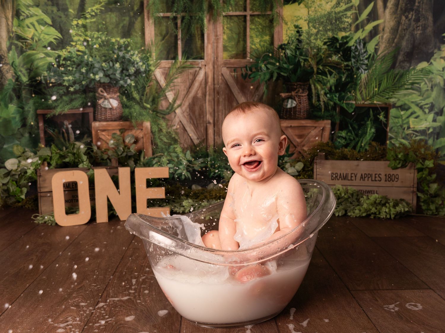 first birthday one year old splashing in tub for cake smash session jungle theme by professional newborn photographer.