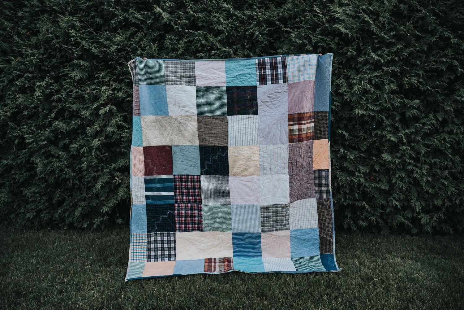 Patchwork memory quilt made with square pieces of dress shirts.