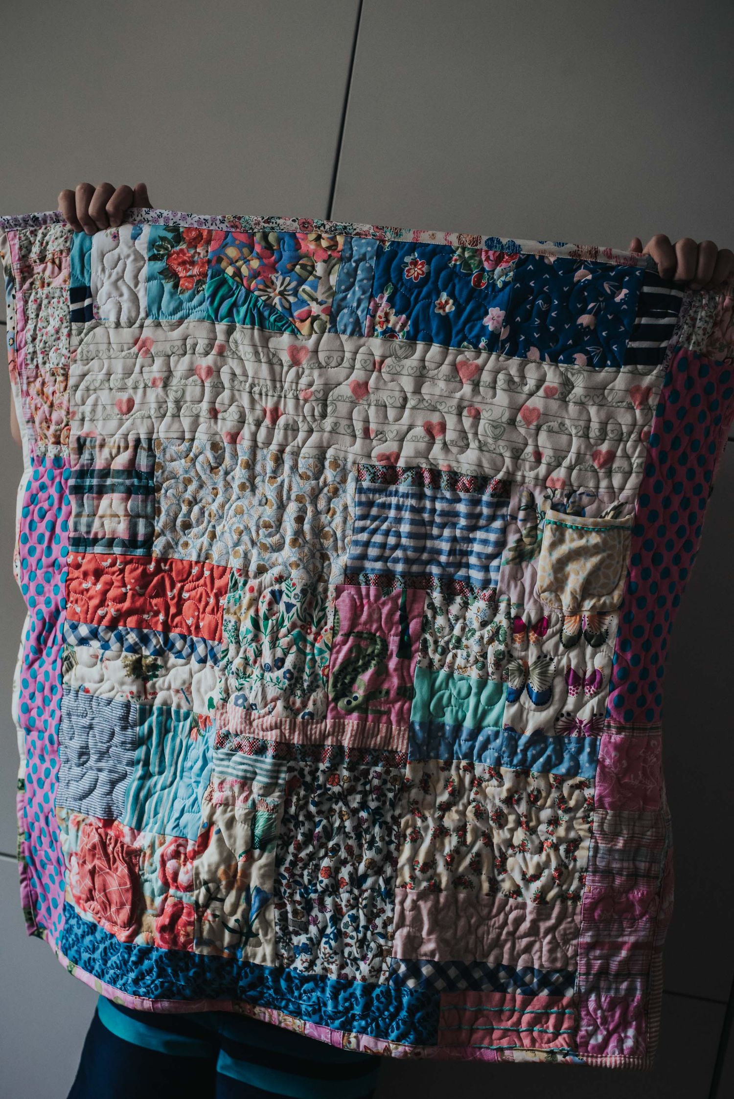 Textured miniature memory quilt made with clothes.
