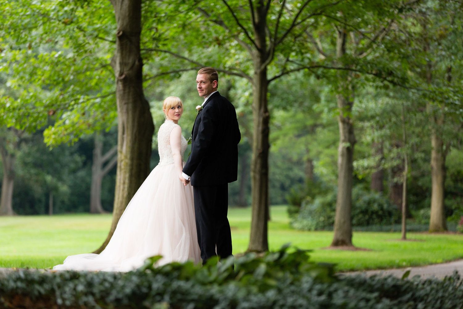 Bride and groom walk around Newfields for wedding pictures.