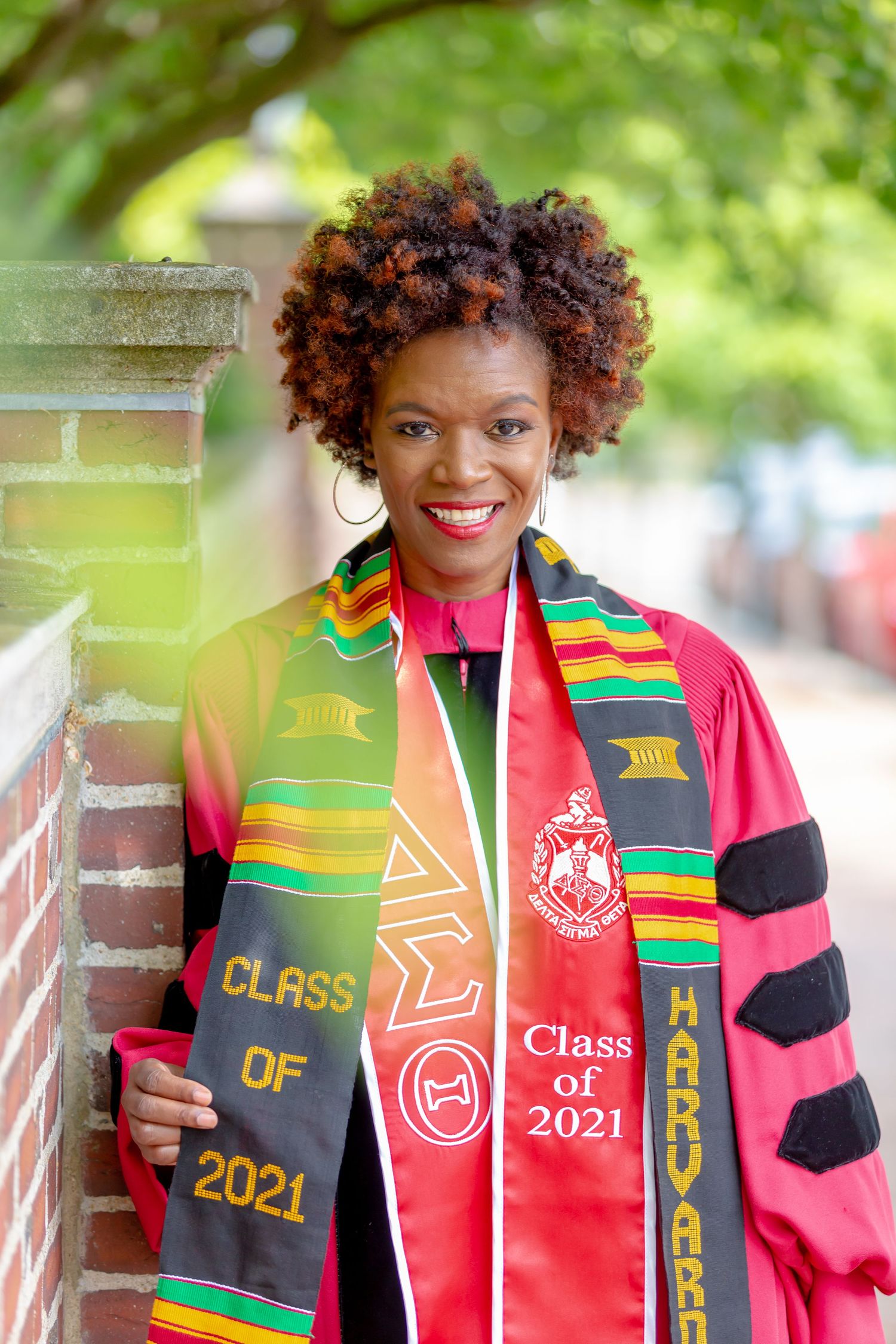 Female in graduation gown leaning on wall