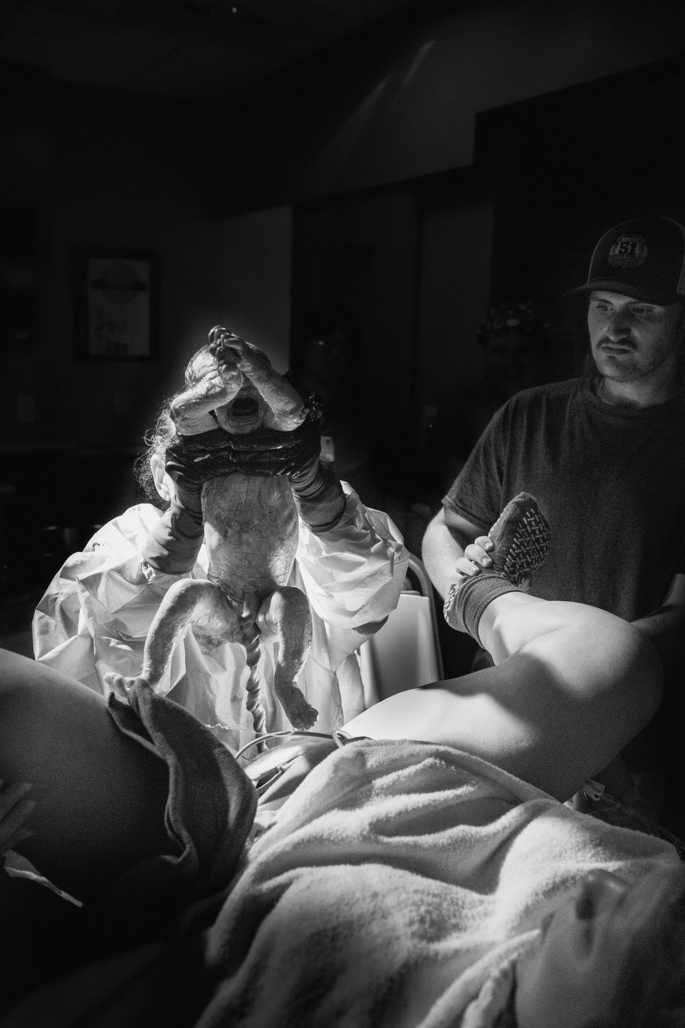 Dramatic black and white photo of medical procedure in low light setting.