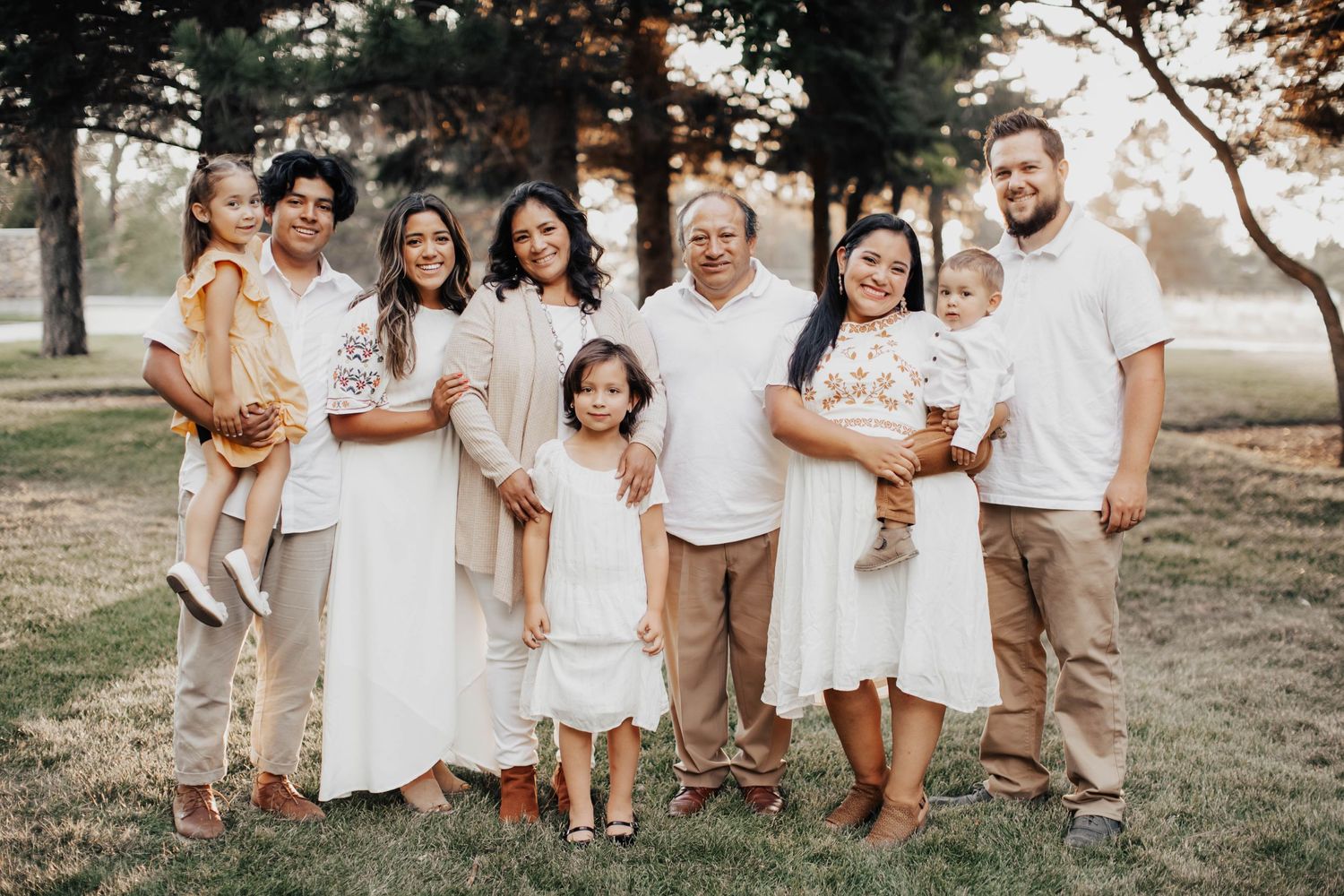 Tucson extended family portrait of multiple generations standing together in a park with soft golden light.