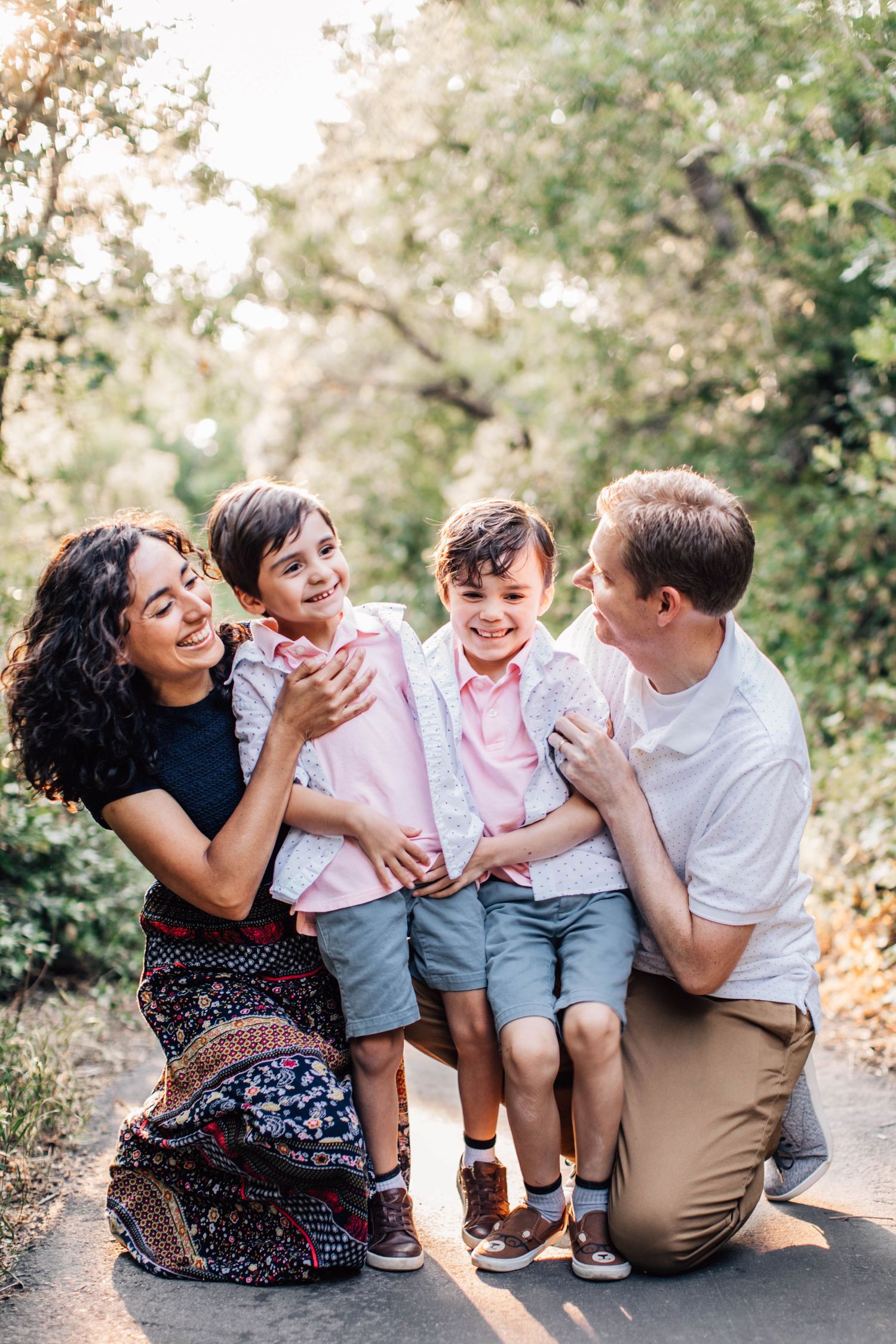Tucson family photo of parents and children hugging closely in shaded greenery with warm natural tones.