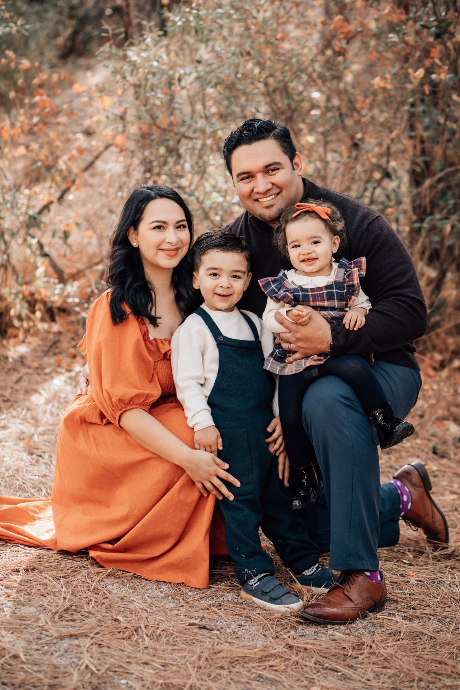 Tucson family portrait of parents and children sitting together in a Mt. Lemmon area with warm, earthy tones.