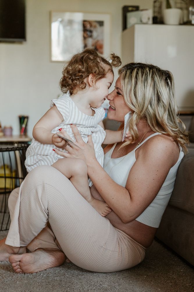 maman enceinte joue avec sa fille pendant une séance photo grossesse en famille à domicile à Lille