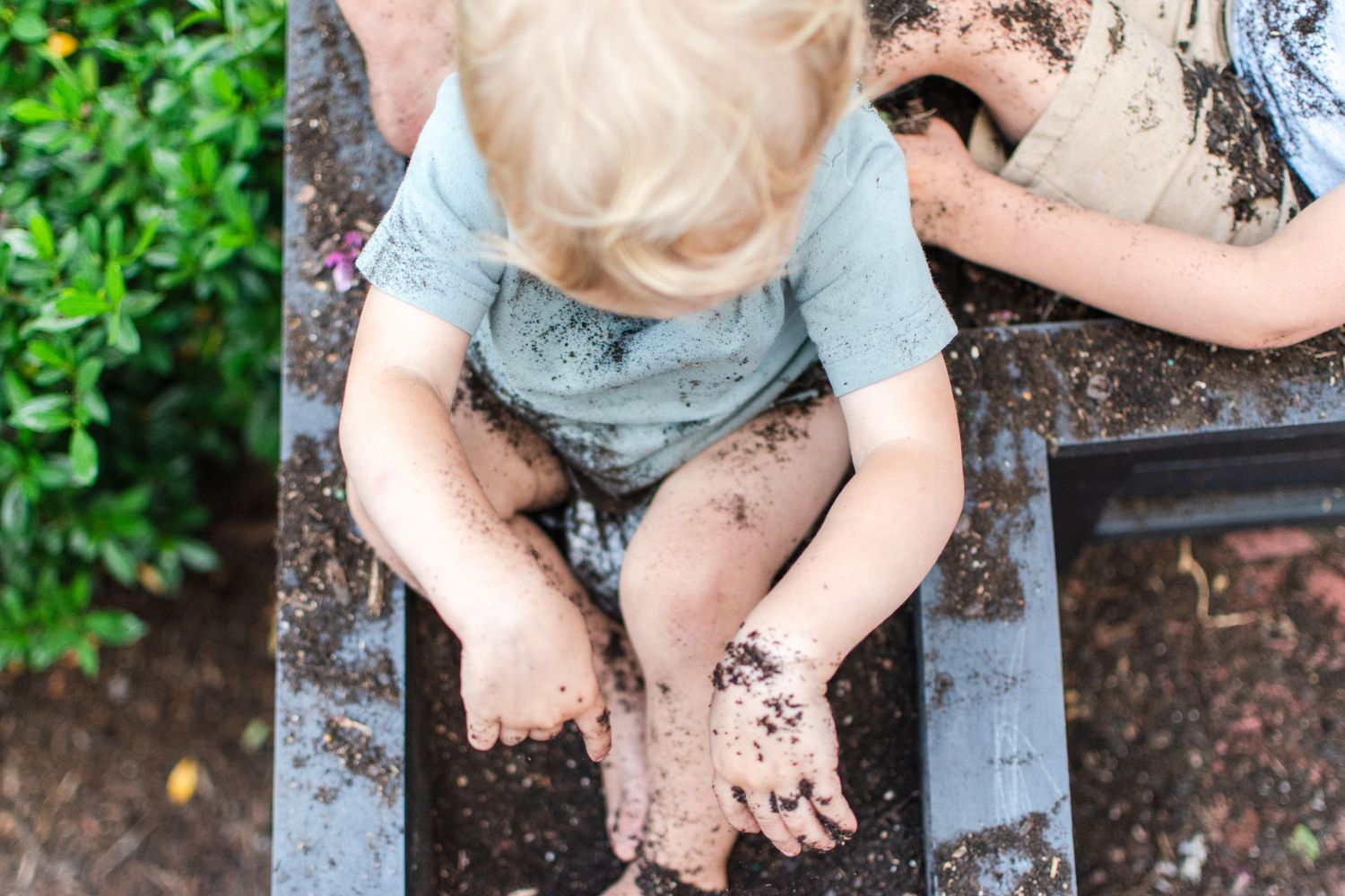 Little boys play in the dirt as their mom was planting spring flowers at their home in Winston-Salem, NC.