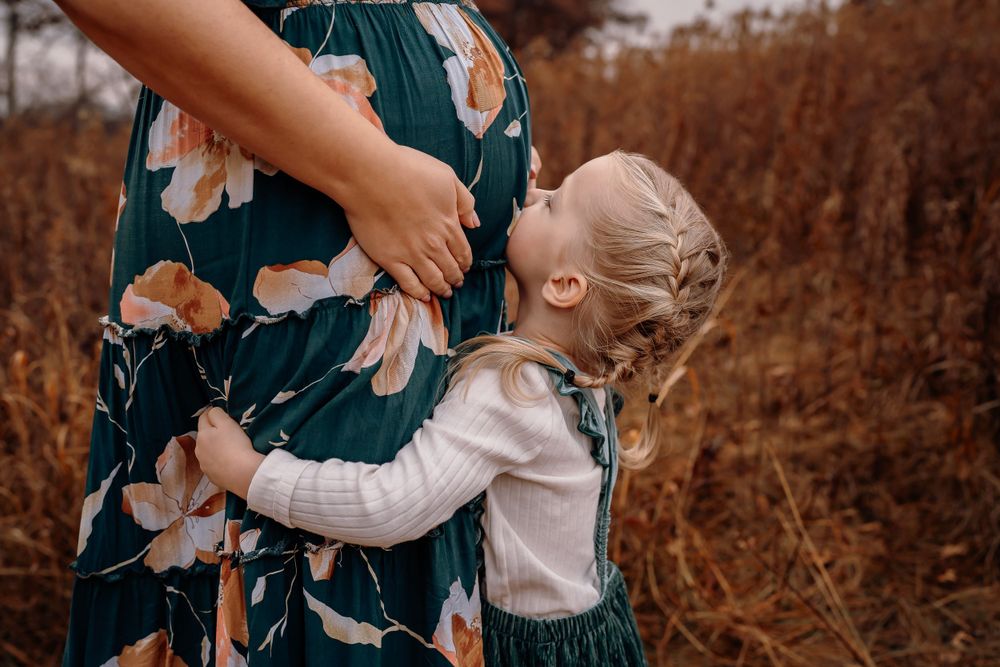 maternity pregnancy photoshoot mom and daughter kissing