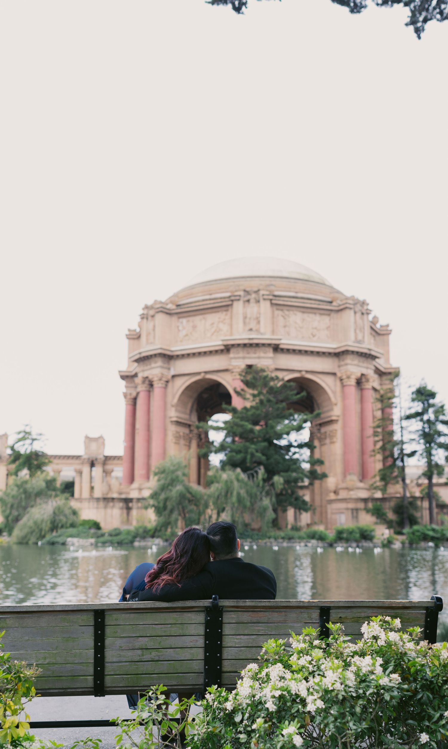 Palace of Fine Arts in San Francisco with bench and garden in foreground.