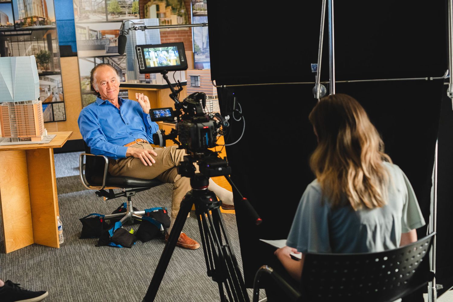Professional video production setup with camera operator and lighting in studio environment.