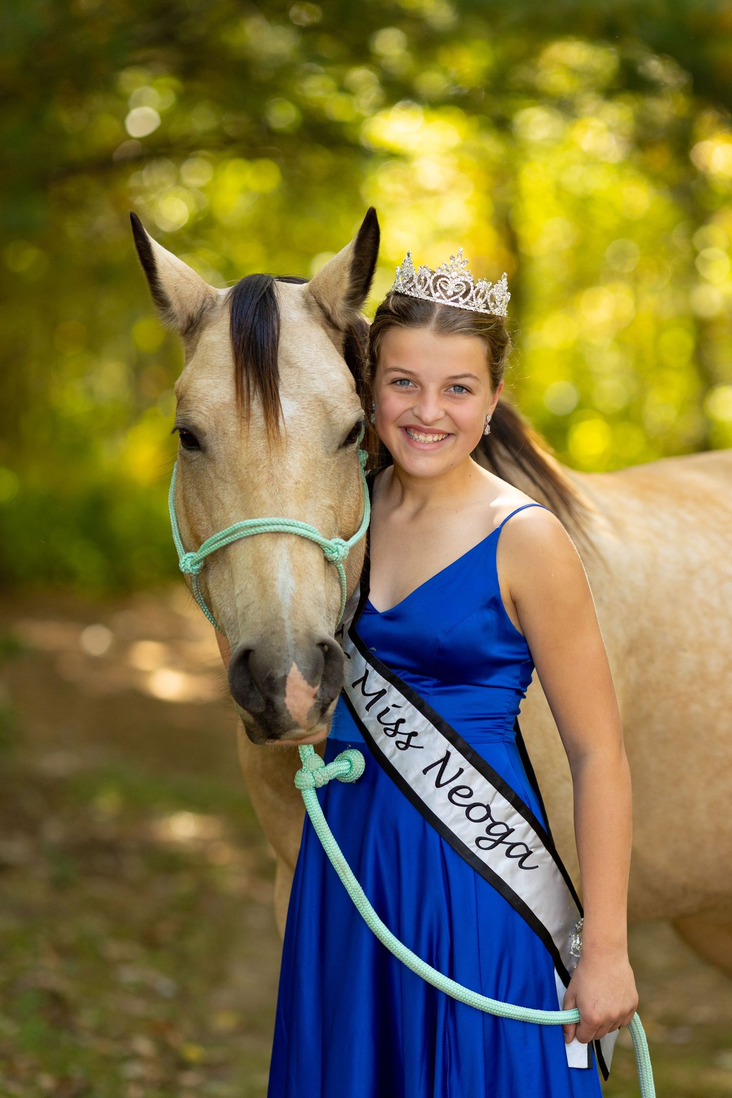 A pageant princess poses with a beautiful buckskin mare.