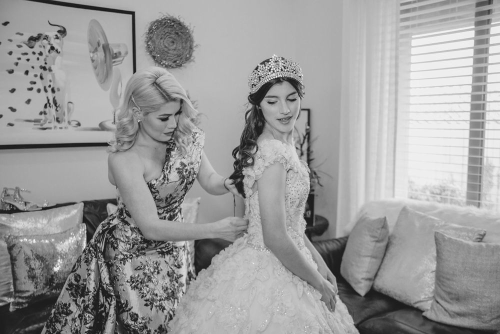 mom helping daughter getting dressed. Verona Event Center. Pharr, Texas. Wedding photography