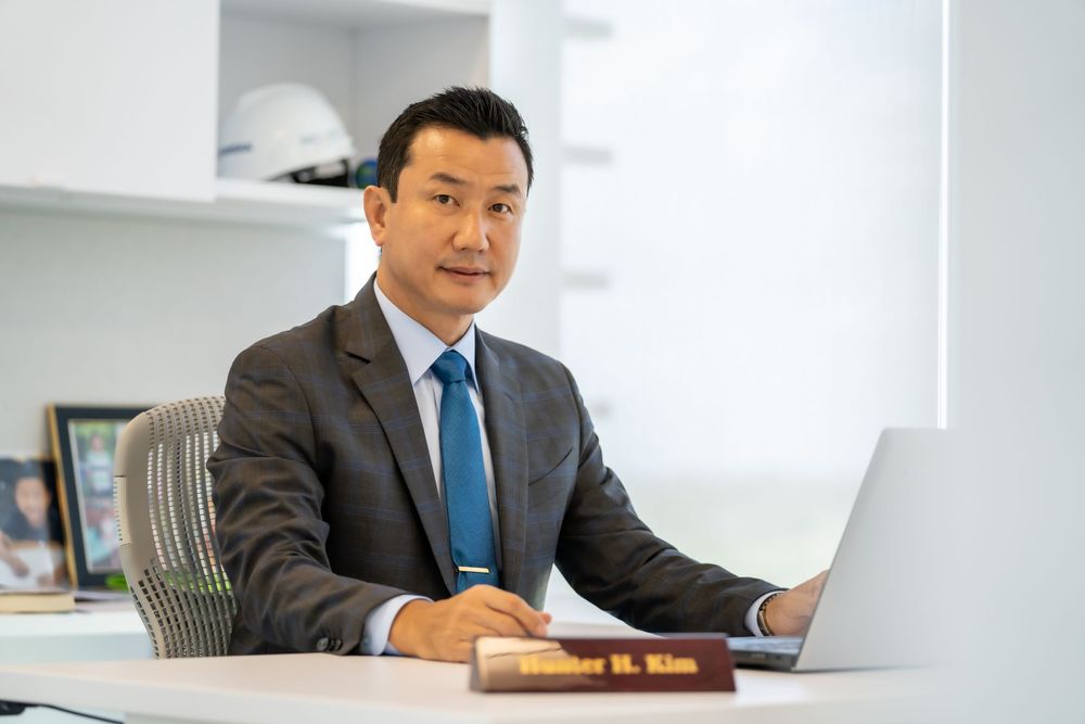 Business professional working on laptop at modern office desk.