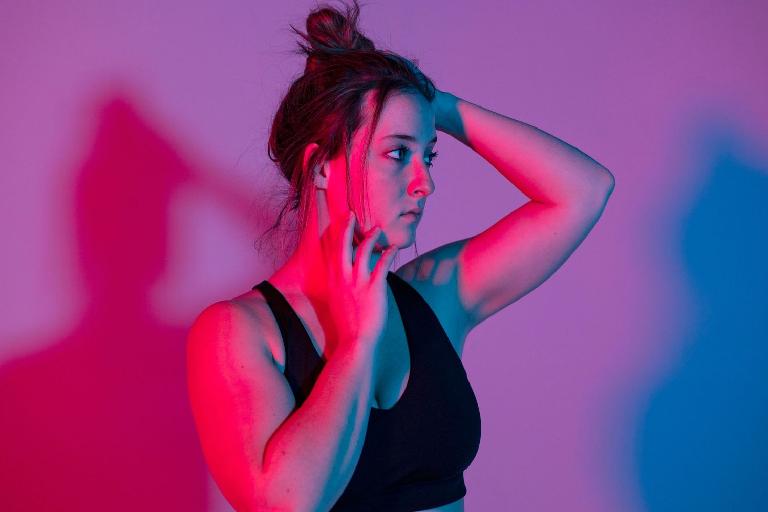 Silhouetted figure poses in dramatic red and purple lighting.