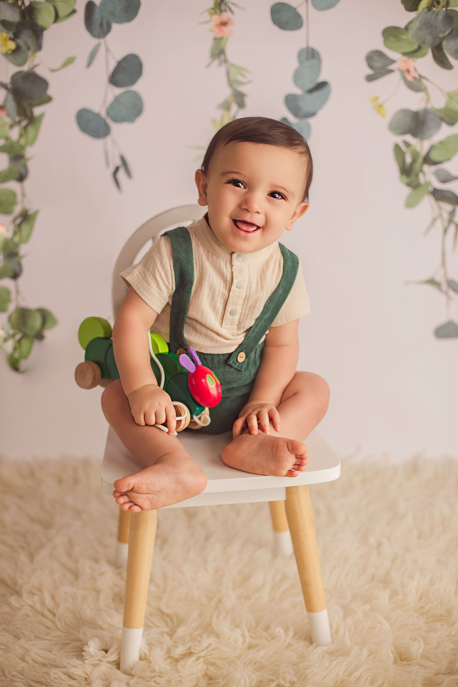 9 months old sitting on a chair holding the hungry caterpillar
