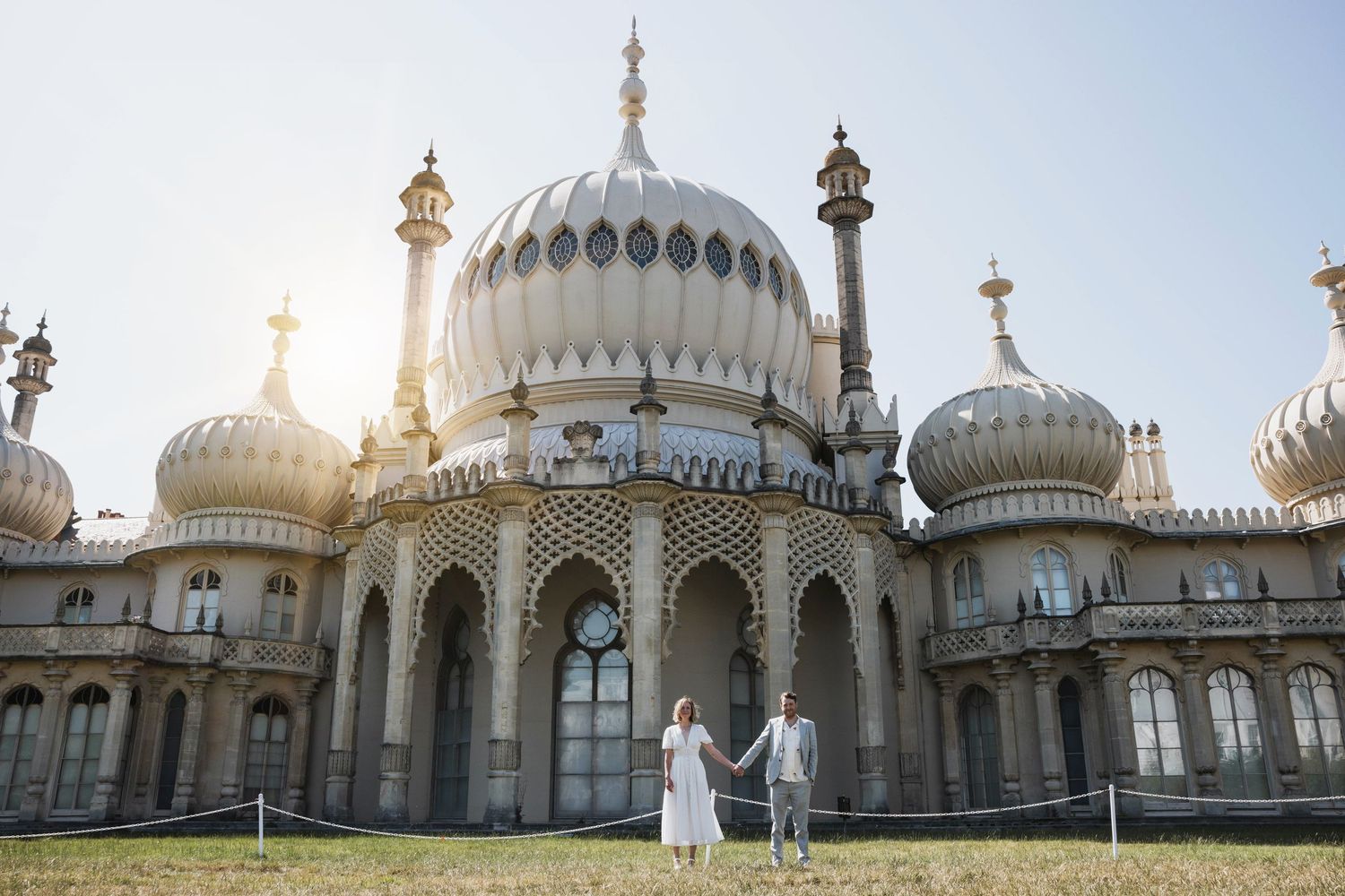 Couple holding hands in front of Brighton Pavilion.