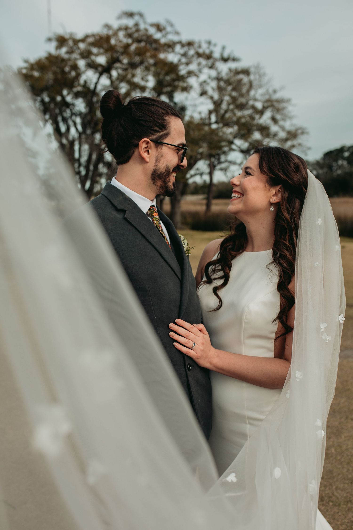 A bride and groom smile at each other after their ceremony at Holy City Brewery
