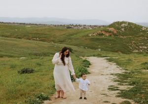 A heartwarming scene of an adult and child walking hand in hand on a mountain path.