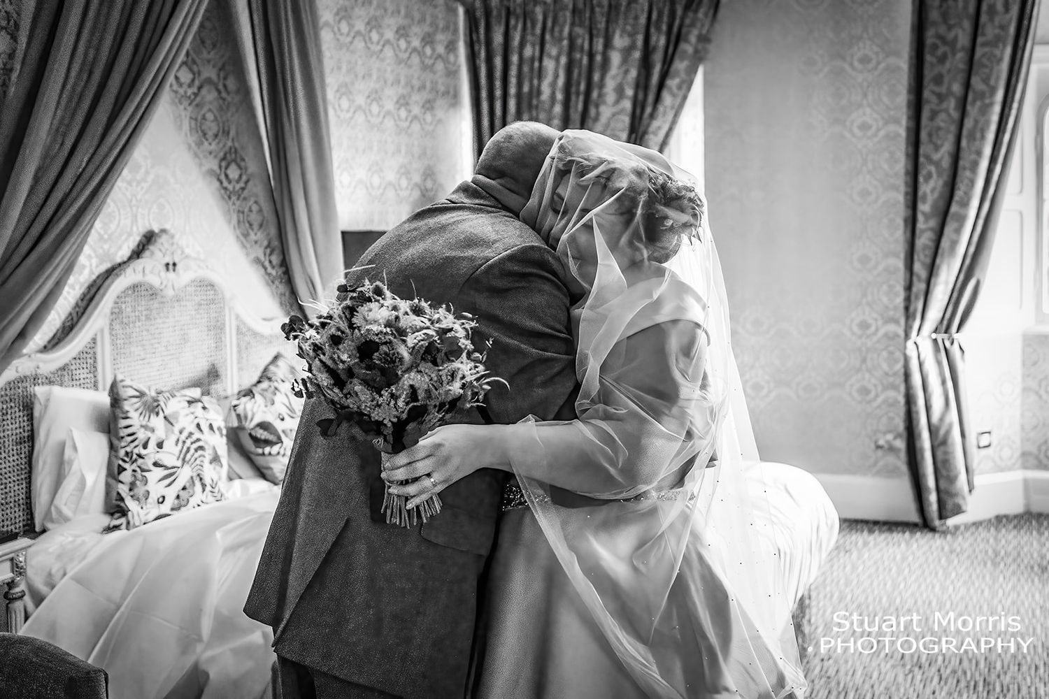 bride gets a hug from her dad during the bridal prep. Ruthin castle wedding photographer.